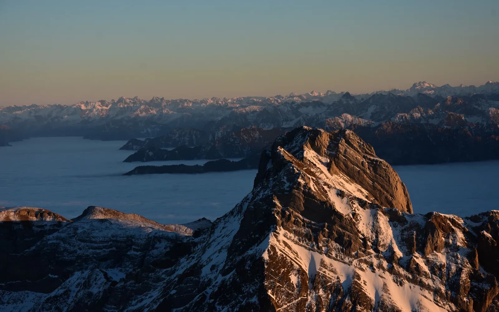 Ein Gipfel im Morgenlicht über dem Nebelmeer