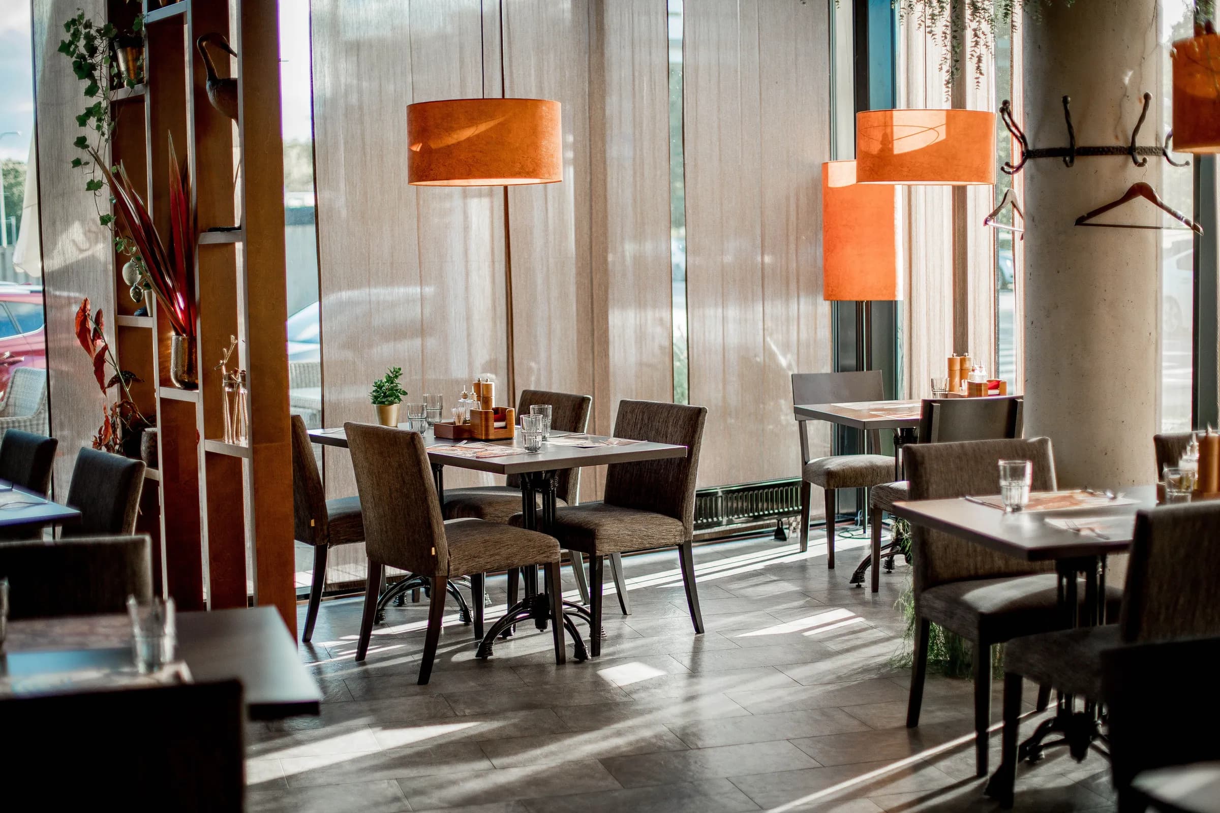Helles Restaurant mit Holztischen und orangen Lampen