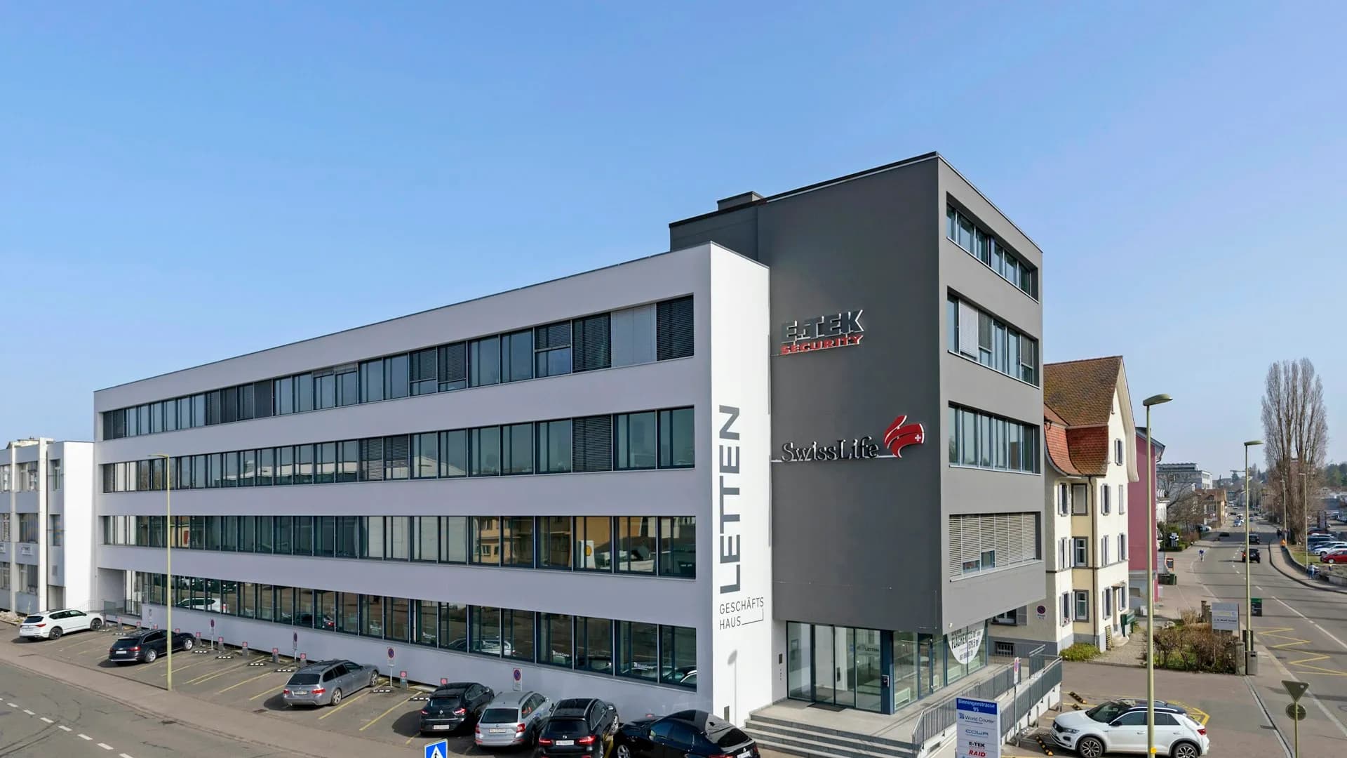 The Letten office building at Binningerstrasse 95 in Allschwil: the light office wing on the left, the grey wing with the Frascati office on the third floor on the right, car park in front